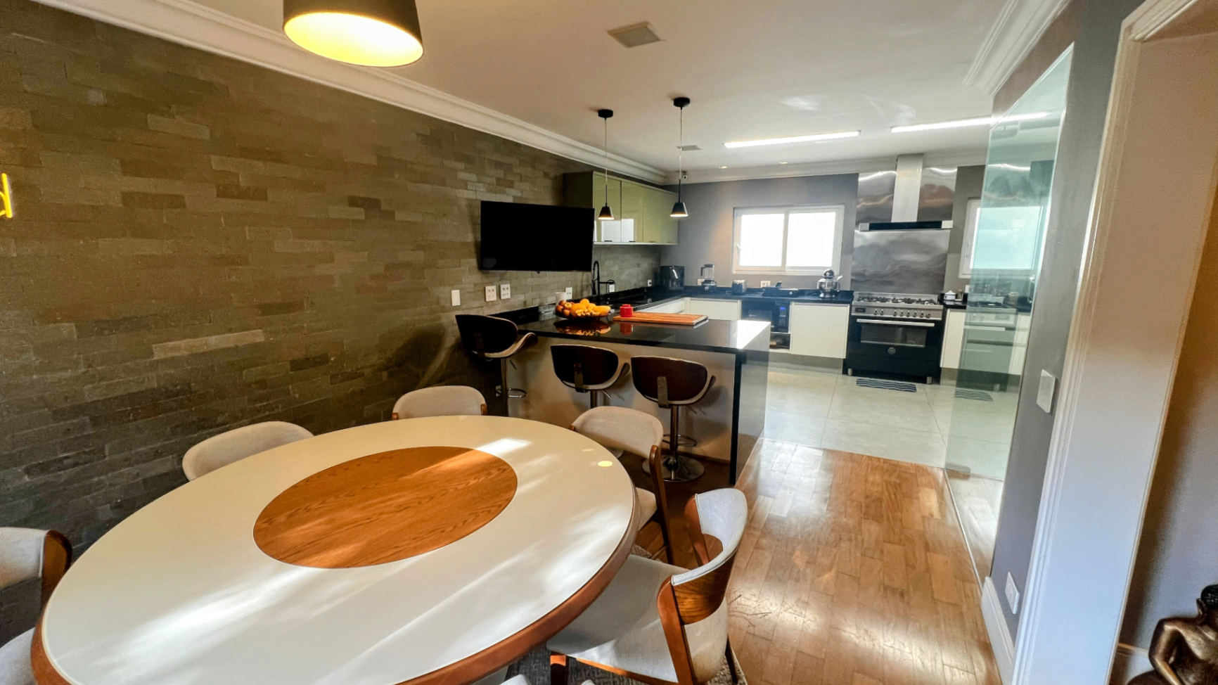 Mesa de jantar redonda branca integrada à cozinha em enfilade