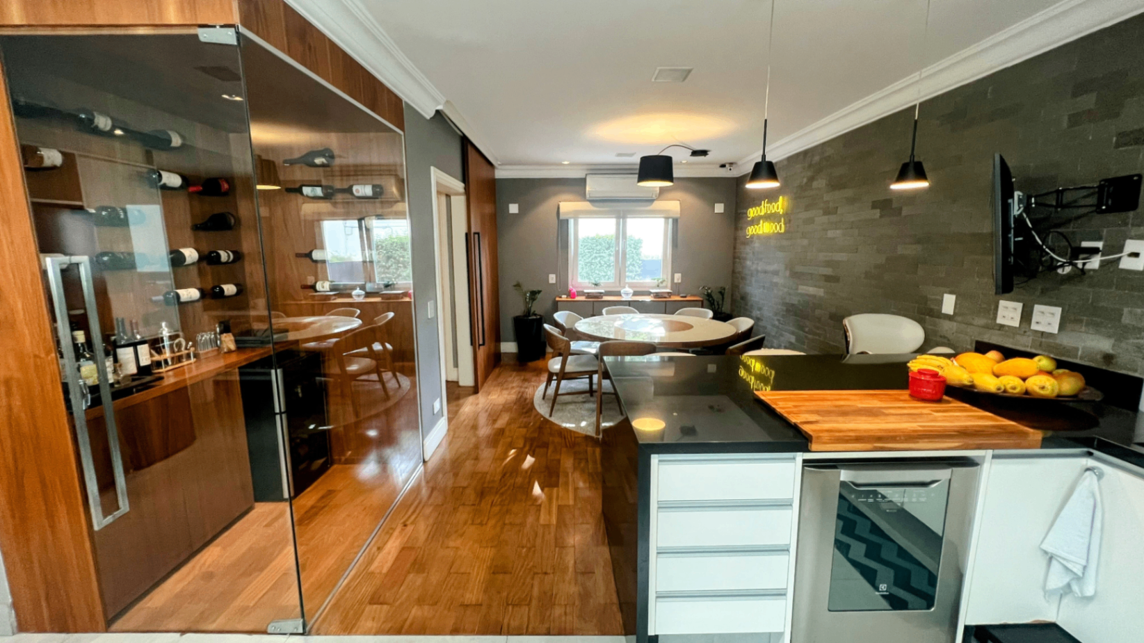 Cozinha vista para a adega com prateleiras de vinho em destaque