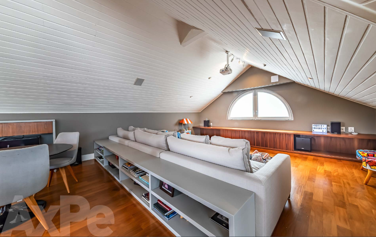 Sótão com lounge, projetor e janela em arco