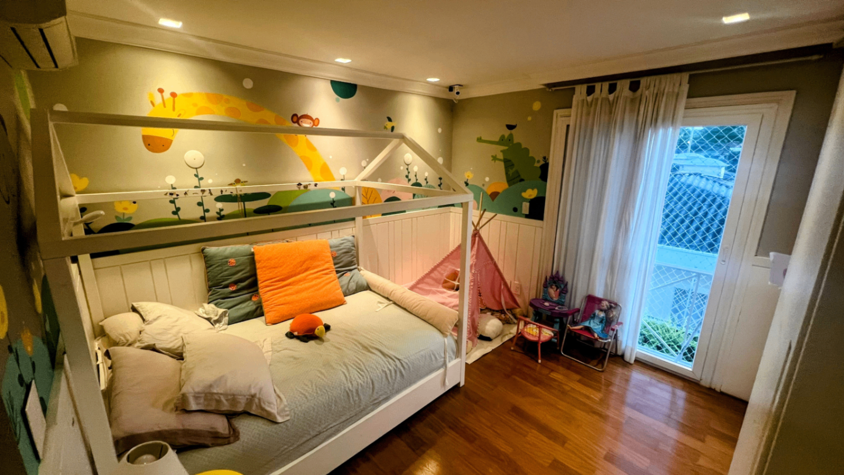 Quarto infantil com cama-casinha e mural pintado de planetas