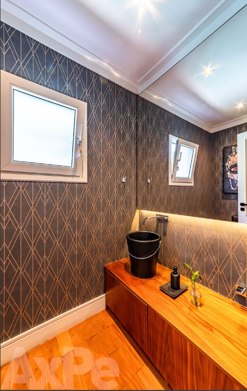 Lavabo com bancada em madeira e papel de parede geométrico
