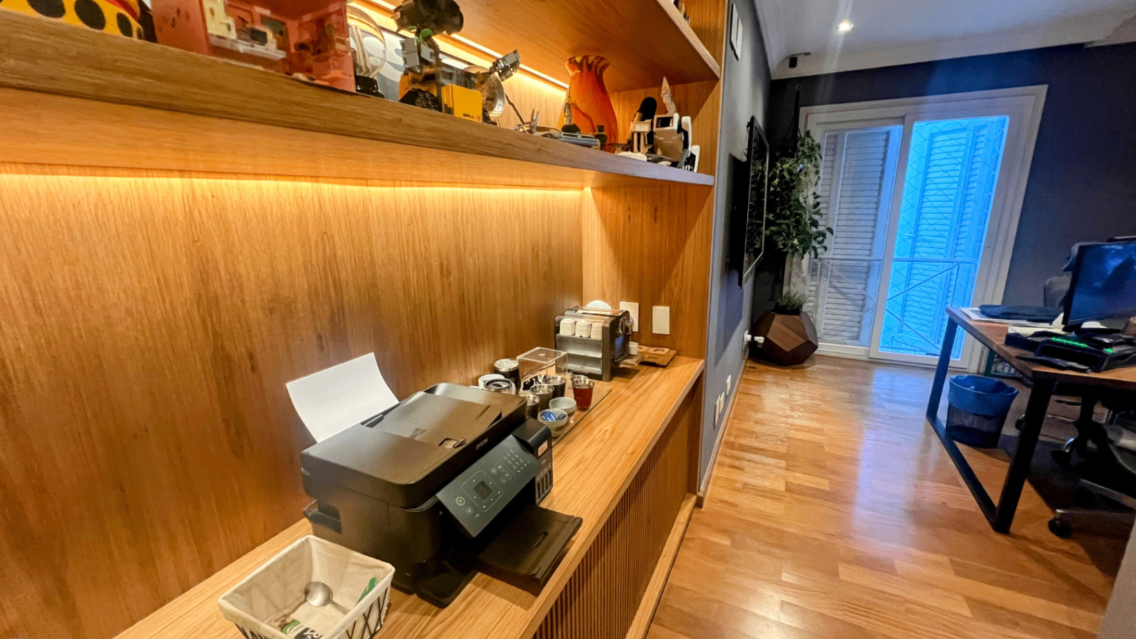 Escritório com marcenaria sob medida, mesa longa e varanda ao fundo