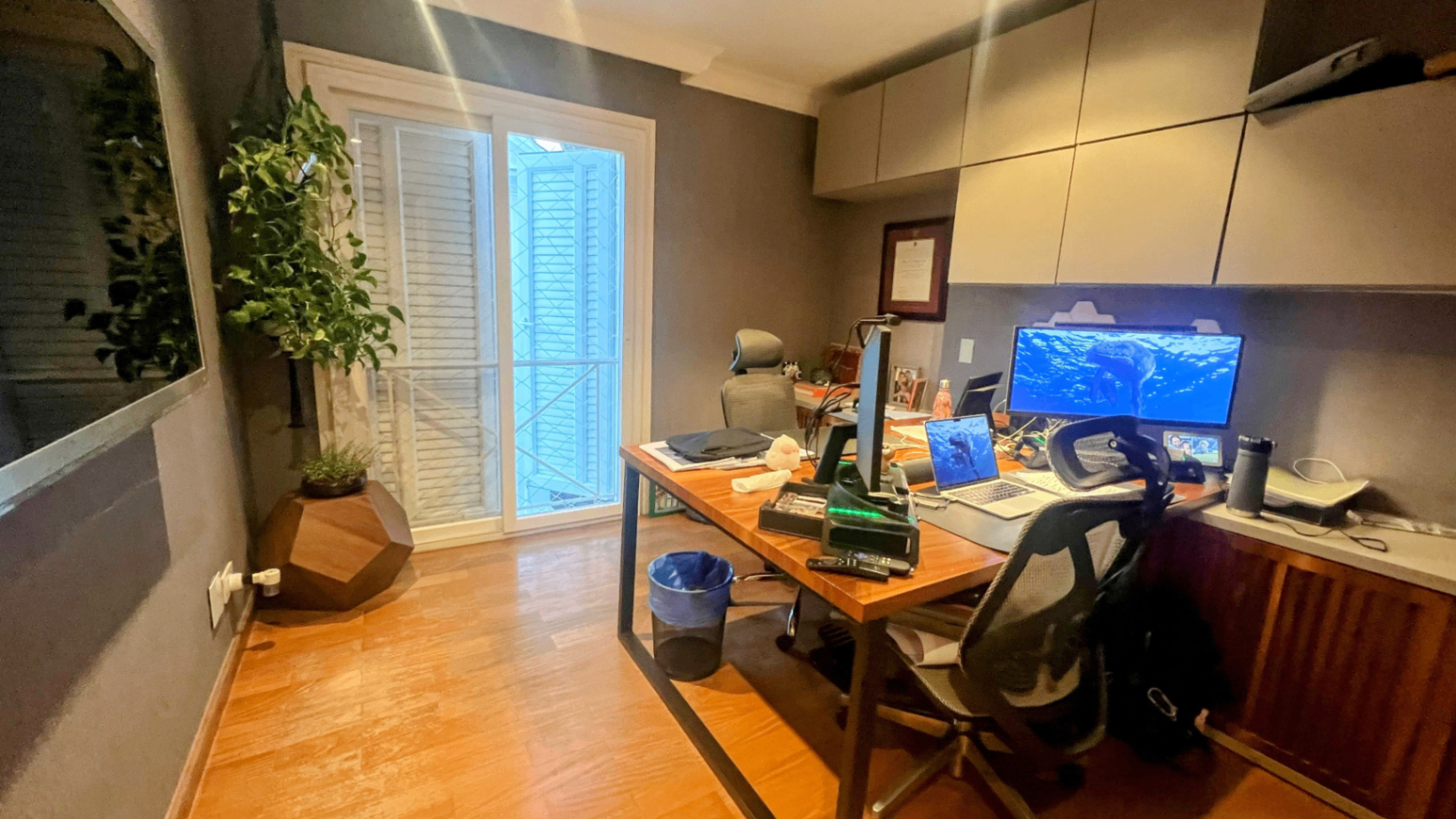 Escritório com mesa de trabalho, monitor e integração com plantas