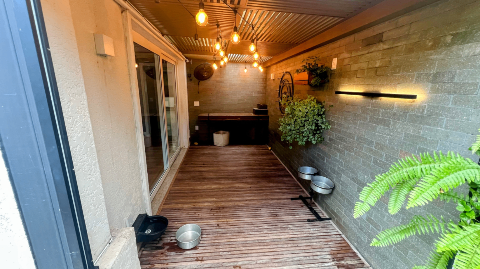 Corredor interno com iluminação cênica de teto e piso de madeira
