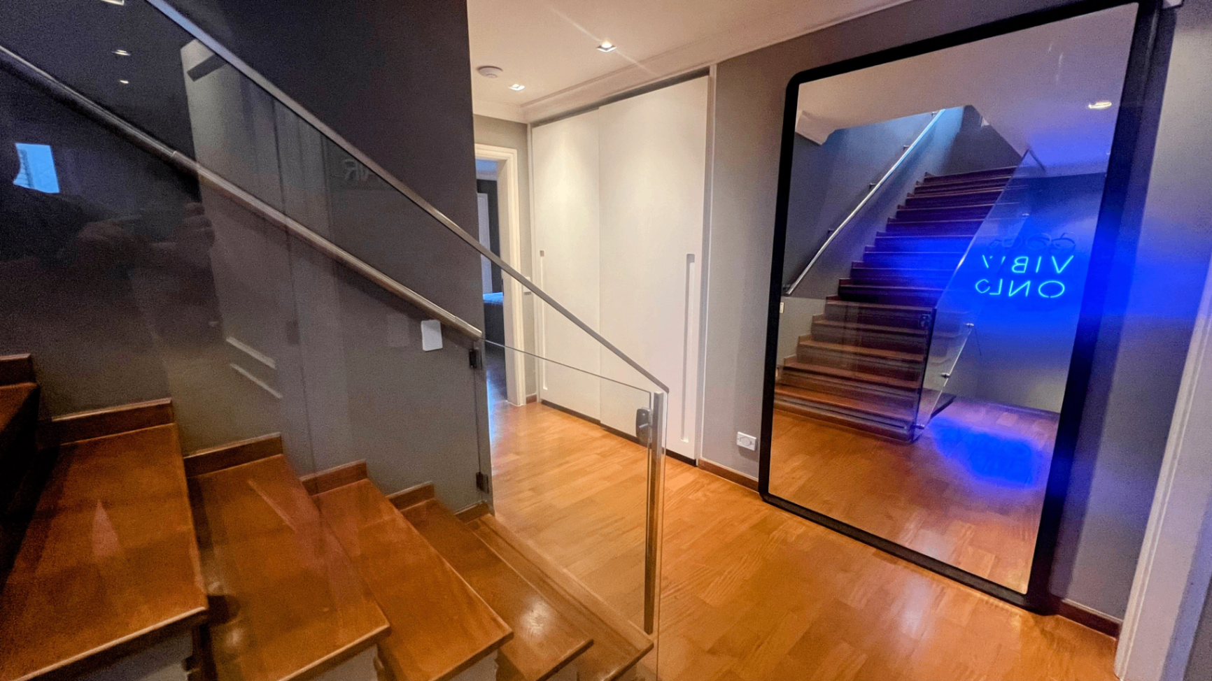 Escada de madeira com iluminação de LED sob os degraus e guarda-corpo de vidro